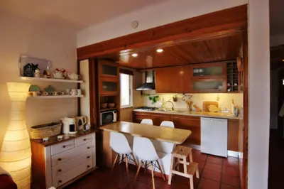 a kitchen with wooden cabinets and a table and chairs at Golf Apartment - Solar do Golfe Condominium in Vilamoura