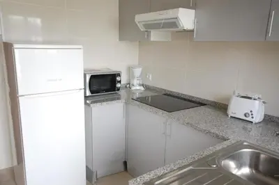 a kitchen with a white refrigerator and a microwave at Apartamento V2 Pedro - By Bedzy in Albufeira