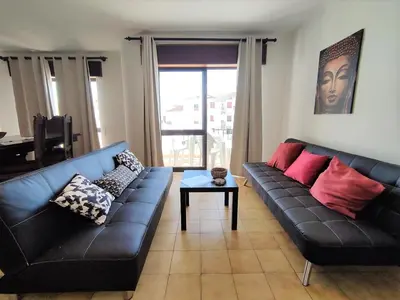 a living room with a black couch and a table at Apartamento V2 Pedro - By Bedzy in Albufeira