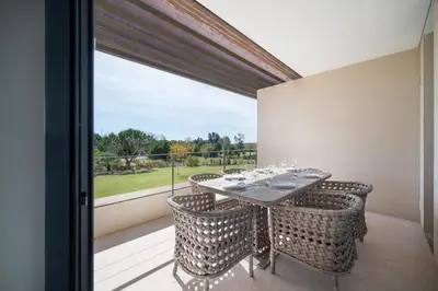 a dining room with a table and chairs on a balcony at Apart L'Orange in Vilamoura