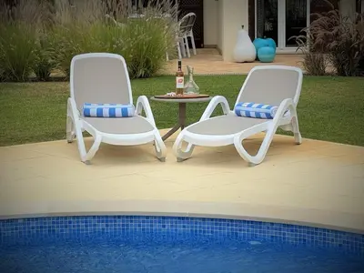 two chairs and a table next to a pool at Villa Cascata, 3 bedroom, Pool, close to Olhos de Agua in Albufeira