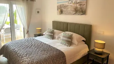 a bedroom with a bed with two lamps and a balcony at Villa Cascata, 3 bedroom, Pool, close to Olhos de Agua in Albufeira
