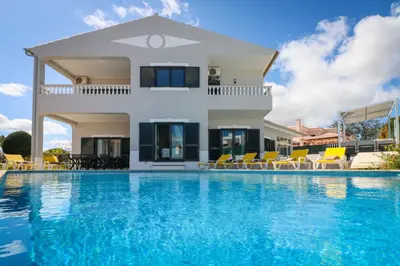 a villa with a swimming pool in front of a house at Villa Alfazema in Albufeira