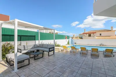 a patio with furniture and a swimming pool at Villa Alfazema in Albufeira
