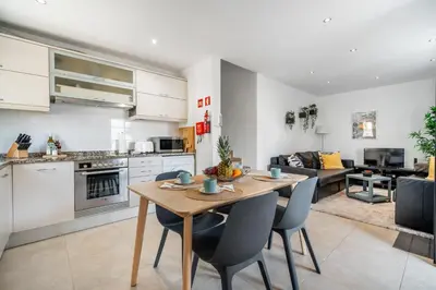 a kitchen and living room with a table and chairs at Villa at the beach in Vale do Lobo