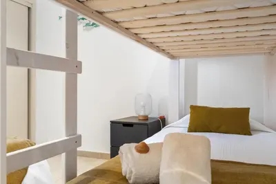 a bedroom with a bed and a chair at Villa at the beach in Vale do Lobo