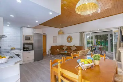 a kitchen and living room with a wooden table and chairs at Villa Casa Calma by Villa Plus in Albufeira