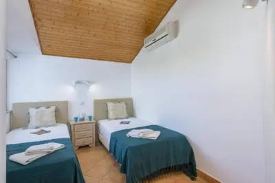 a bedroom with two beds and a wooden ceiling at Villa Casa Calma by Villa Plus in Albufeira