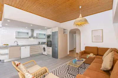 a living room with a couch and a kitchen at Villa Casa Calma by Villa Plus in Albufeira