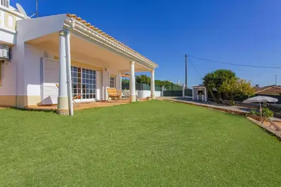 a backyard of a house with a lawn at Villa Colina do Sol by Villa Plus in Paderne