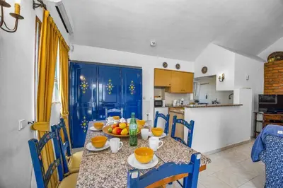 a kitchen with a table with a bowl of fruit on it at Villa Pinheiro Oura by Villa Plus in Albufeira