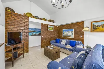 a living room with a blue couch and a brick wall at Villa Pinheiro Oura by Villa Plus in Albufeira
