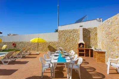 a patio with a table and chairs and a fireplace at Villa Quinta dos Abacates by Villa Plus in Olhos de Água