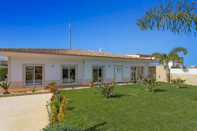 a house with a lawn in front of it at Villa Quinta dos Abacates by Villa Plus in Olhos de Água