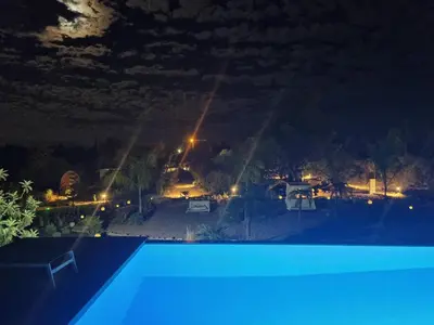 a view of a swimming pool at night at Cosy Guest House - Villa das Alfarrobas in Algoz