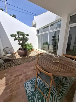 a wooden table and chairs on a patio at Cosy Guest House - Villa das Alfarrobas in Algoz