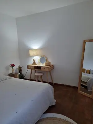 a bedroom with a bed and a table with a mirror at Cosy Guest House - Villa das Alfarrobas in Algoz