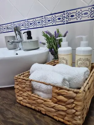 a basket with towels and a sink in a bathroom at Cosy Guest House - Villa das Alfarrobas in Algoz