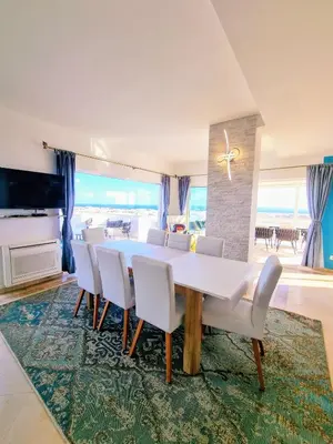 a dining room with a white table and chairs at Penthouse Rentalbufeira in Albufeira