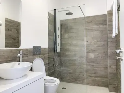 a bathroom with a toilet and a glass shower at DIANA BEACH HOUSE in Albufeira