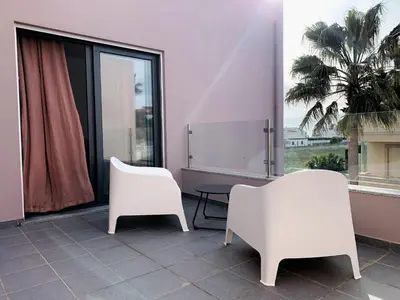 two white chairs and a table in front of a window at DIANA BEACH HOUSE in Albufeira