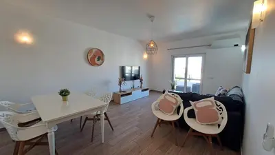 a living room with a couch and a table and chairs at Albufeira Oura Beach Apartment in Albufeira