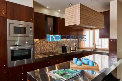 a kitchen with wooden cabinets and a counter top at Apartamento em Albufeira a 10 min da praia * 50070/AL in Albufeira