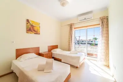 a room with two beds and a large window at Villa Galé in Guia