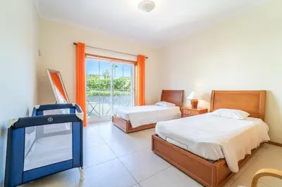 a bedroom with two beds and a wooden door at Villa Galé in Guia