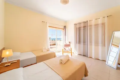 a hotel room with two beds and a balcony at Villa Galé in Guia