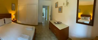 a hotel room with a bed and a mirror at Albufeira Praia São Rafael Sun Apartment in Albufeira