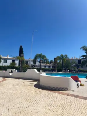 a swimming pool with a table and a red chair at Albufeira Praia São Rafael Sun Apartment in Albufeira