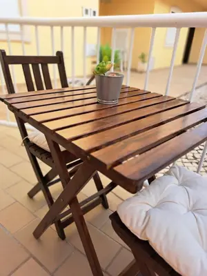 a wooden table with a potted plant on a balcony at Flat Caballero in Guia