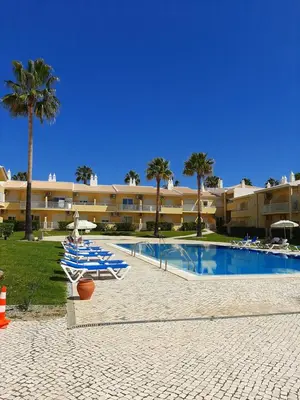 a resort with a pool and palm trees and a building at Flat Caballero in Guia