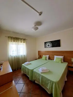 a bedroom with a bed with a green blanket at Flat Caballero in Guia