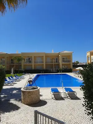 a swimming pool with lounge chairs and a building at Flat Caballero in Guia