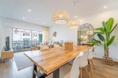 a dining room with a wooden table and chairs at Palmeiras Apartment - 19A by HelloVacations in Albufeira