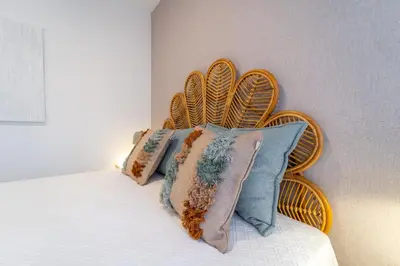a bed with a wooden head board with pillows at Palmeiras Apartment - 19A by HelloVacations in Albufeira