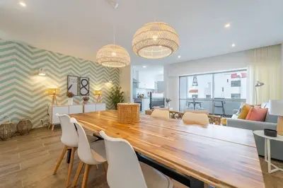 a dining room with a large wooden table and chairs at Palmeiras Apartment - 19A by HelloVacations in Albufeira