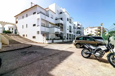 a motorcycle parked in front of a white building at Holiday 1 Bed Apartment with pool in Albufeira in Albufeira