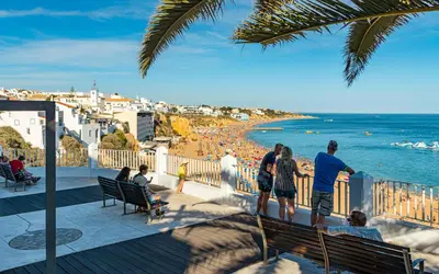 a group of people standing on a balcony looking at the beach at Holiday 1 Bed Apartment with pool in Albufeira in Albufeira