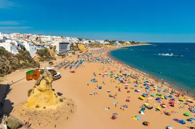 a beach with a lot of people and the ocean at Holiday 1 Bed Apartment with pool in Albufeira in Albufeira