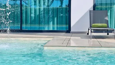 a chair sitting in front of a swimming pool at Villa Waterfall - Clever Details, luxury, 5min walking from the center in Vilamoura