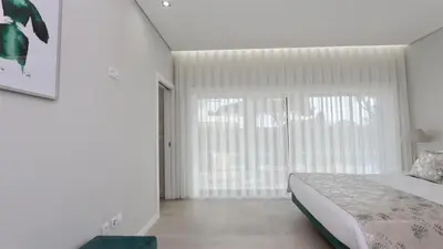 a bedroom with a bed and a large window at Villa Waterfall - Clever Details, luxury, 5min walking from the center in Vilamoura