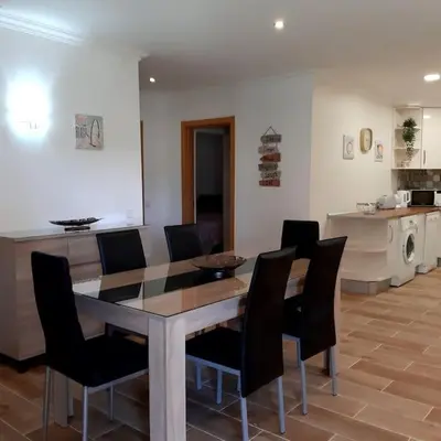 a dining room with a table and chairs and a kitchen at Quinta Vita- Vila Laranja in Almancil