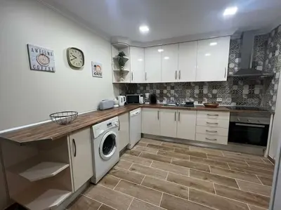 a kitchen with white cabinets and a washer and dryer at Quinta Vita- Vila Laranja in Almancil