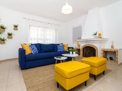 a living room with a blue couch and a fireplace at Villa Bel Mar by Stay ici Algarve Holiday Rental in Guia