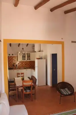 a living room with a kitchen and a table and chairs at Quinta do Amendoal o melhor da Natureza no Algarve in Terras Novas