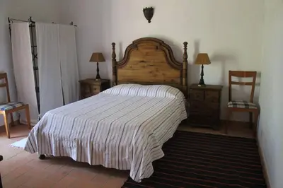 a bedroom with a bed and two tables and two chairs at Quinta do Amendoal o melhor da Natureza no Algarve in Terras Novas