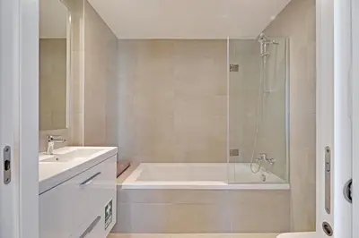 a bathroom with a tub and a sink and a shower at Apartamento Vista Jardim by Portucasa in Albufeira